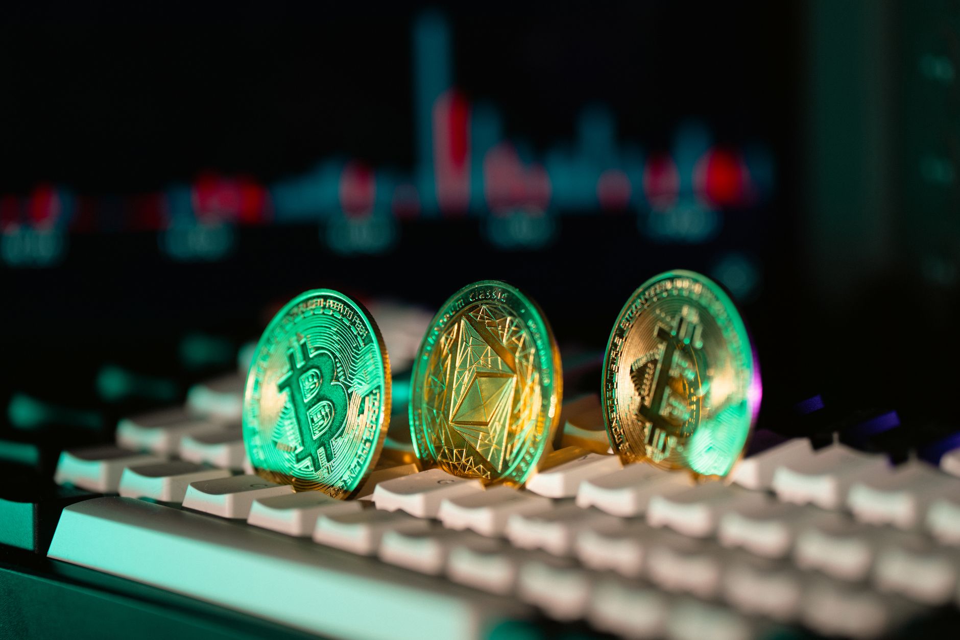 Ilustrasi: Close-up of Bitcoin and Ethereum coins placed on a keyboard, with market charts in the background.