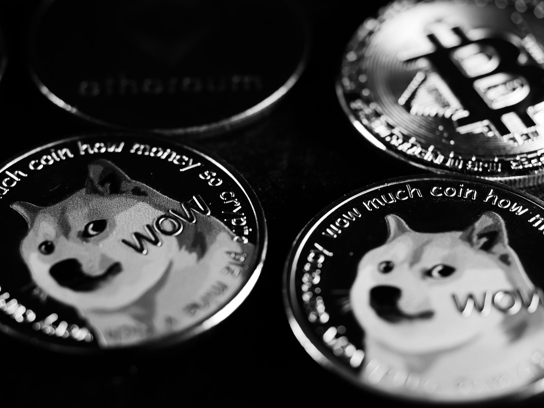 Ilustrasi: Monochrome image focusing on physical Dogecoin and Bitcoin coins, highlighting cryptocurrency.