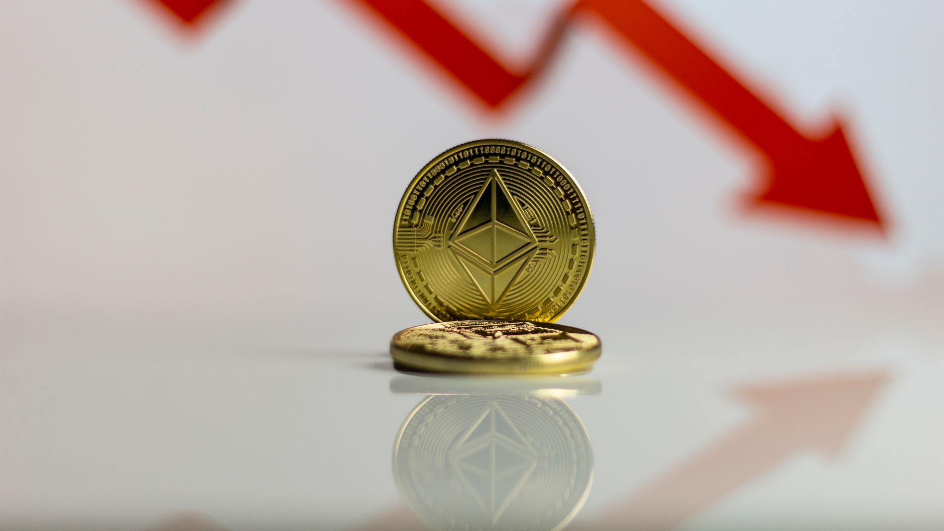 Ilustrasi: Close-up of Ethereum cryptocurrency with red downward arrow, symbolizing market decline.