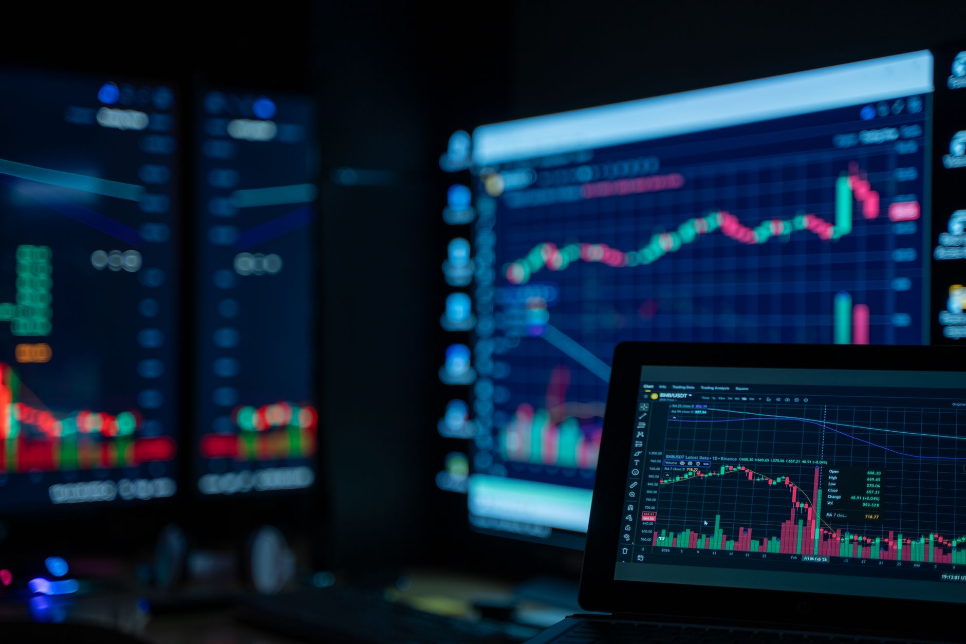 Ilustrasi: Monitors displaying stock market charts in a dimly lit room, perfect for finance and trading themes.