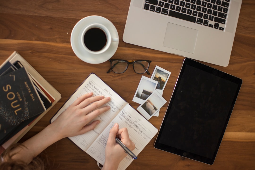 Ilustrasi: Person holding ballpoint pen writing on notebook