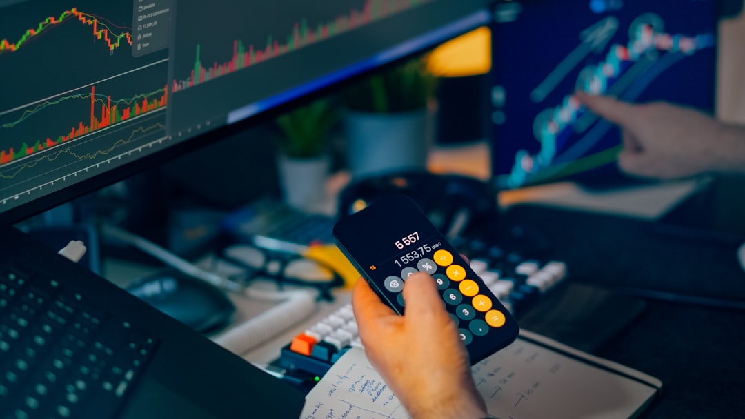 Ilustrasi: Trader analyzing stock market charts on computer screens with calculator.