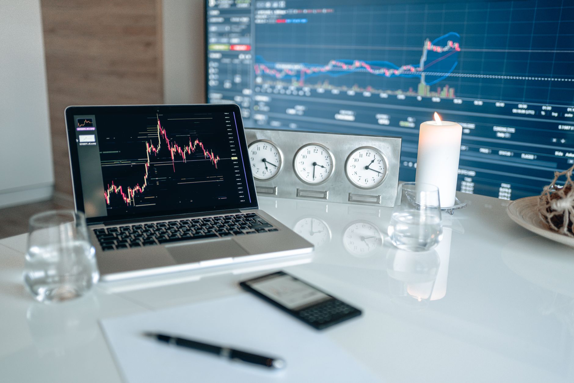 Ilustrasi: A modern workspace featuring financial charts and multiple clocks on a white table, ideal for trading.