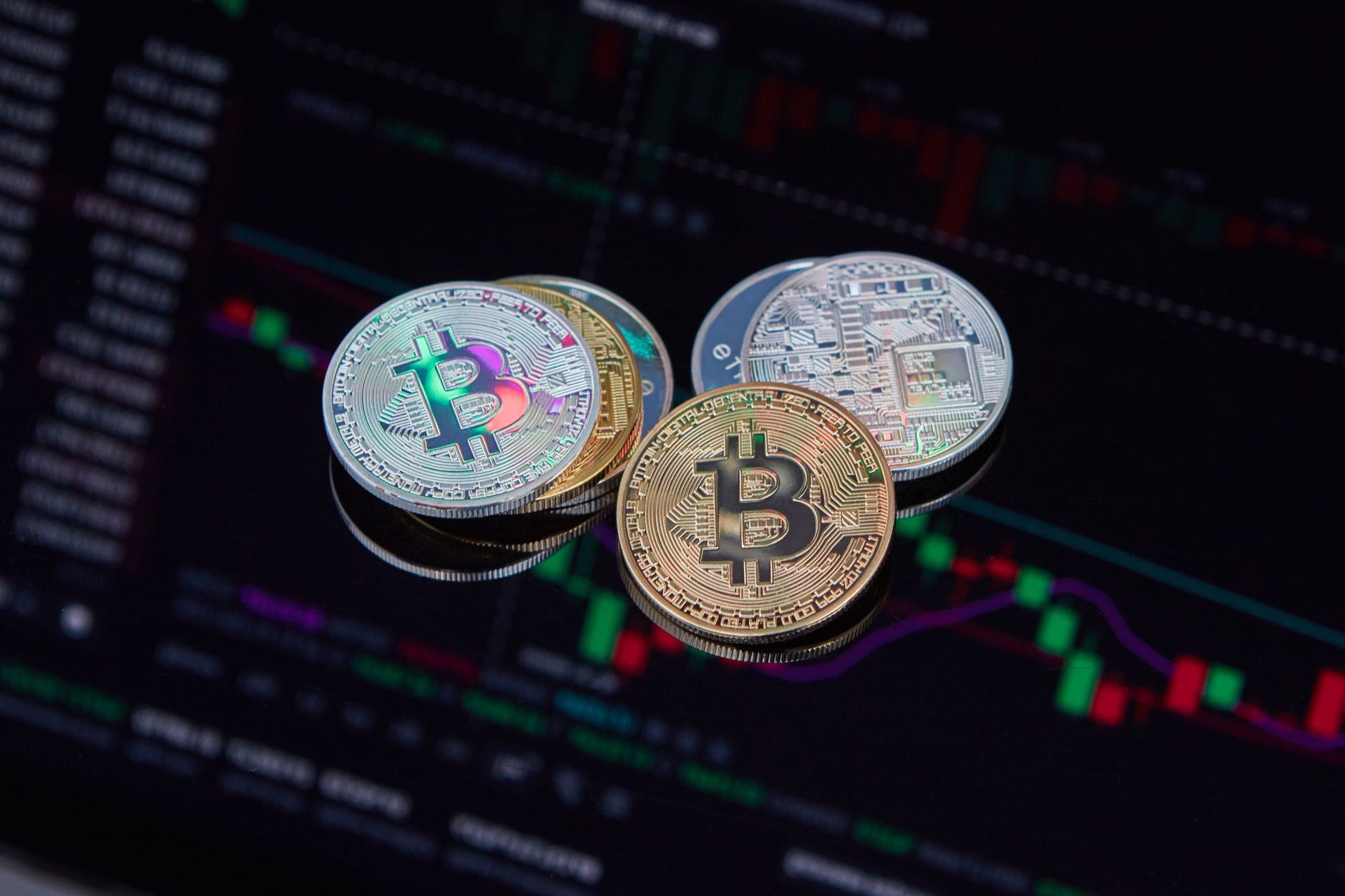 Ilustrasi: Close-up of Bitcoin cryptocurrency coins with a digital market chart background, symbolizing finance and technology trends.