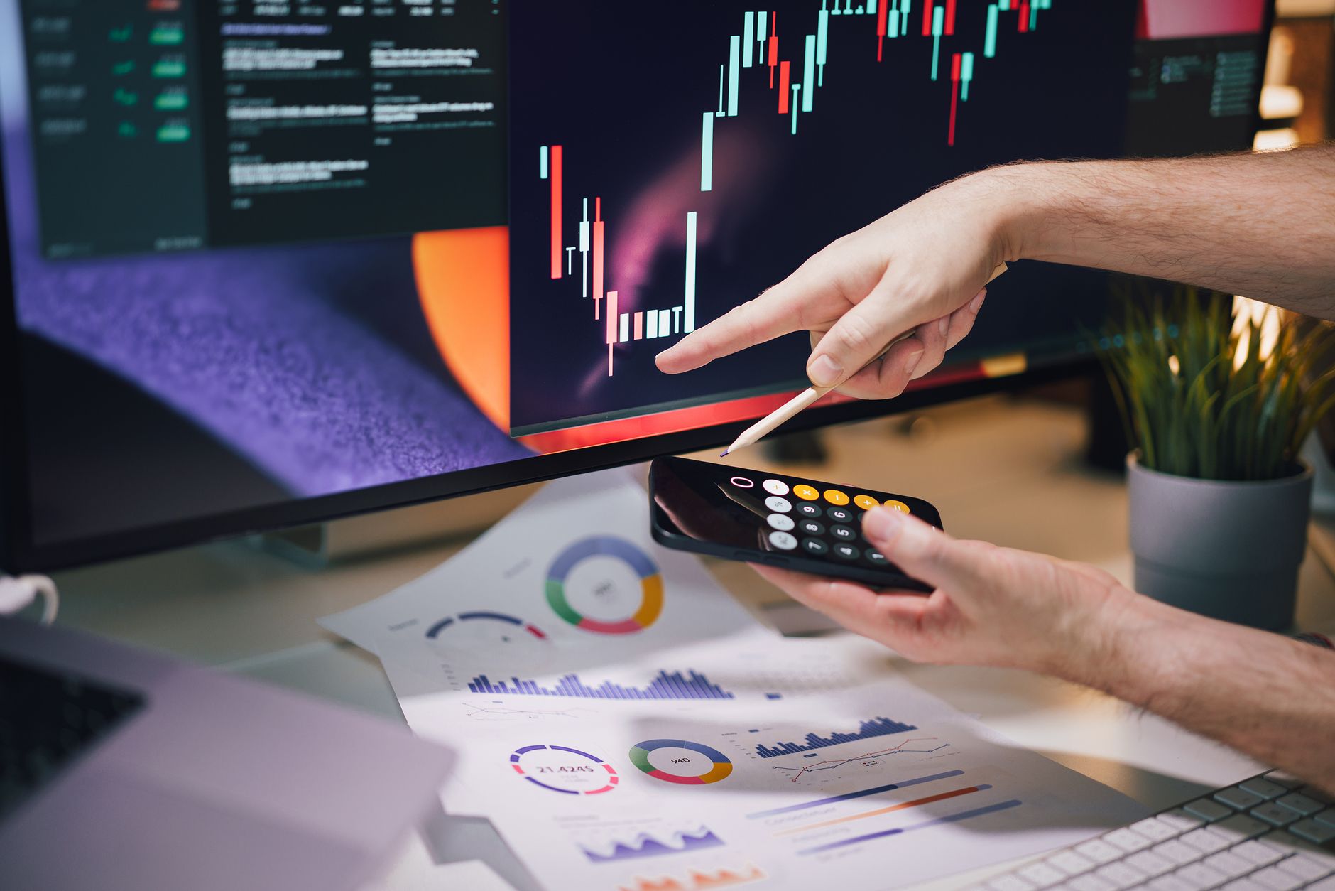 Ilustrasi: Hands analyzing stock market data on monitor and smartphone in office setting.