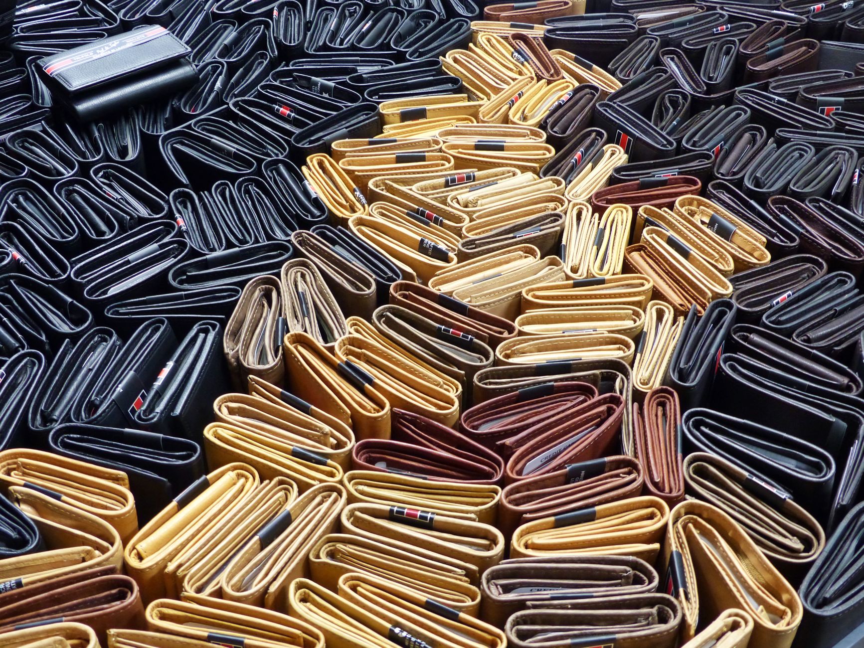Ilustrasi: A vivid display of folded leather wallets in various colors arranged artfully.
