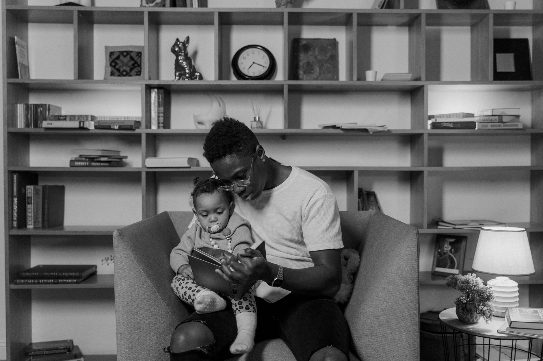 Ilustrasi: A father and child reading together in a cozy, book-filled room showcasing bonding and family time.