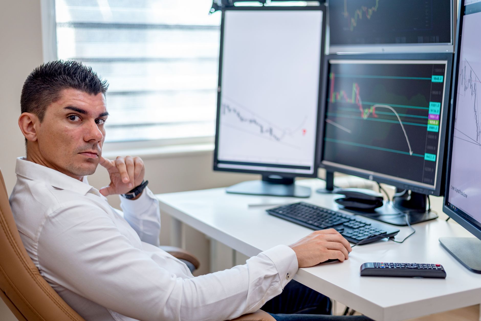 Ilustrasi: Professional stock market analyst monitoring data on multiple screens at a workstation.