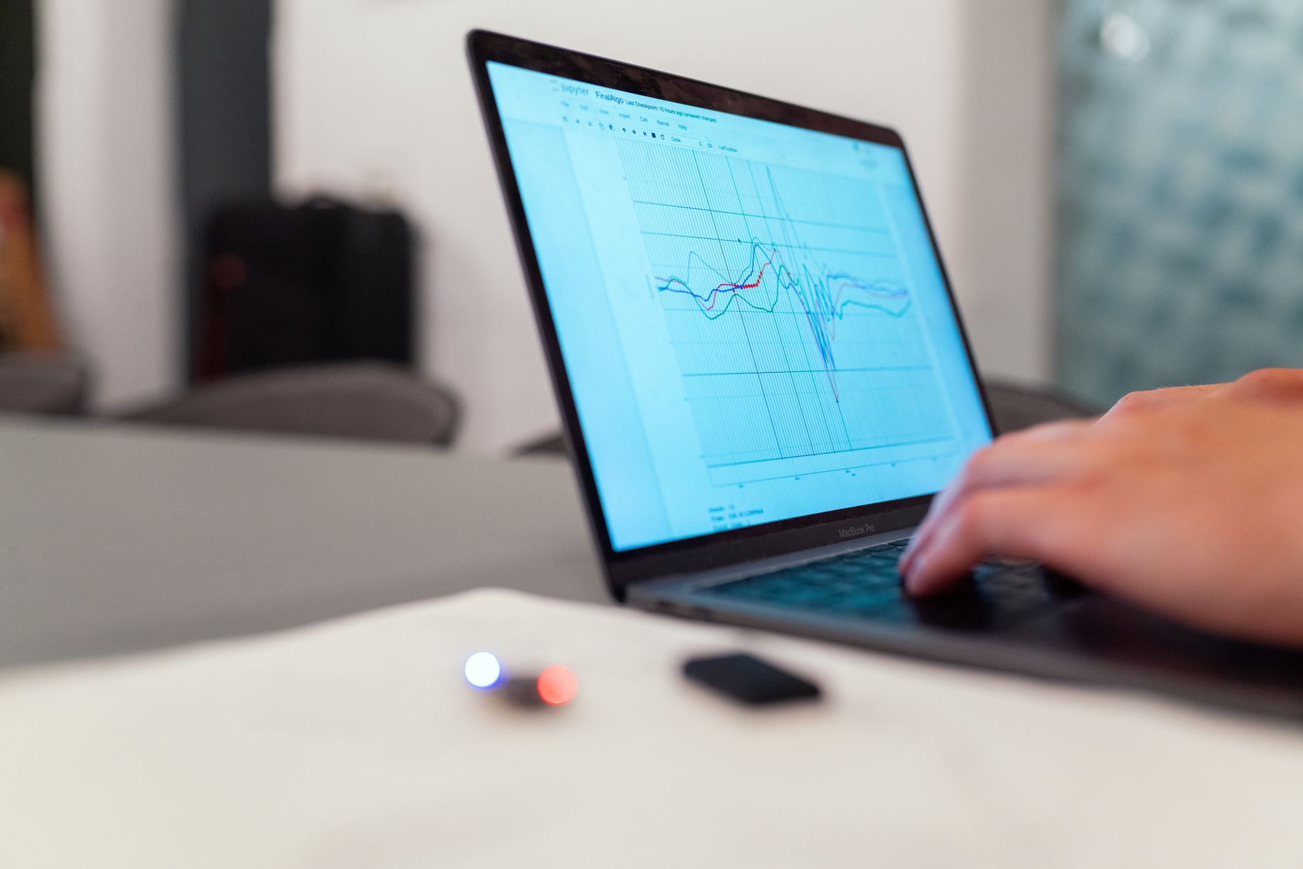 Ilustrasi: A person working on a graph analysis on a laptop for data monitoring and research.