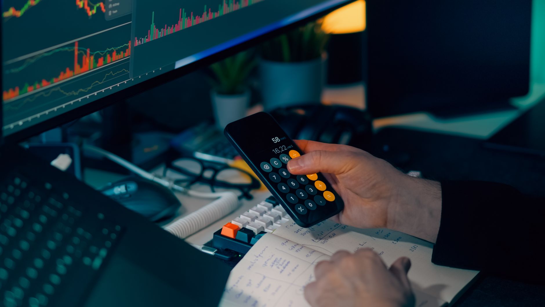 Ilustrasi: Business analysis with calculator and computer monitor displaying financial graphs and charts.