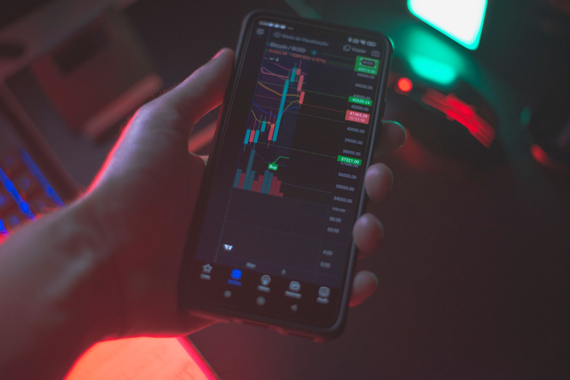 Ilustrasi: Hand holding smartphone displaying cryptocurrency trading app with financial data.
