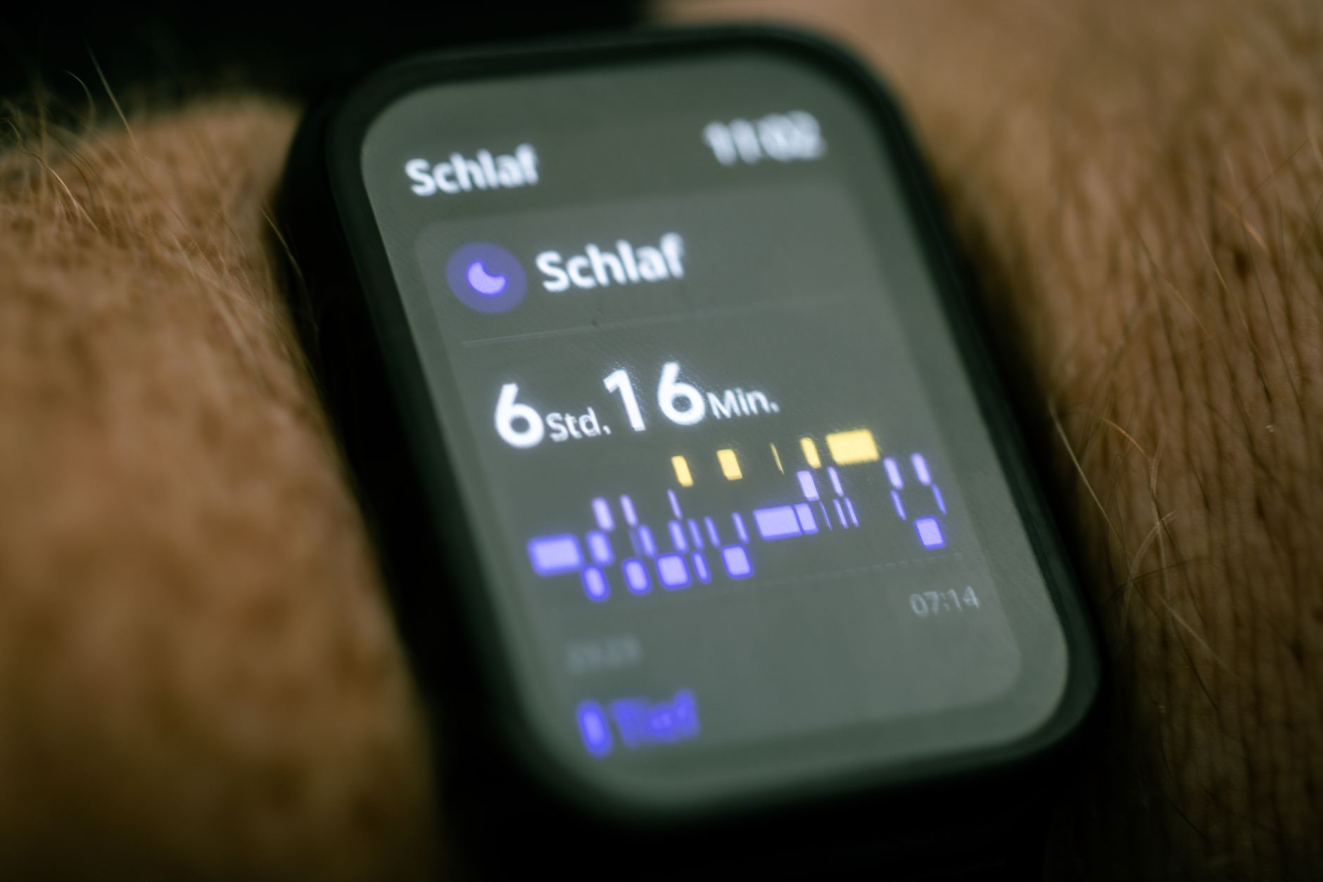 Ilustrasi: Close-up of a smartwatch displaying sleep tracking data in German.