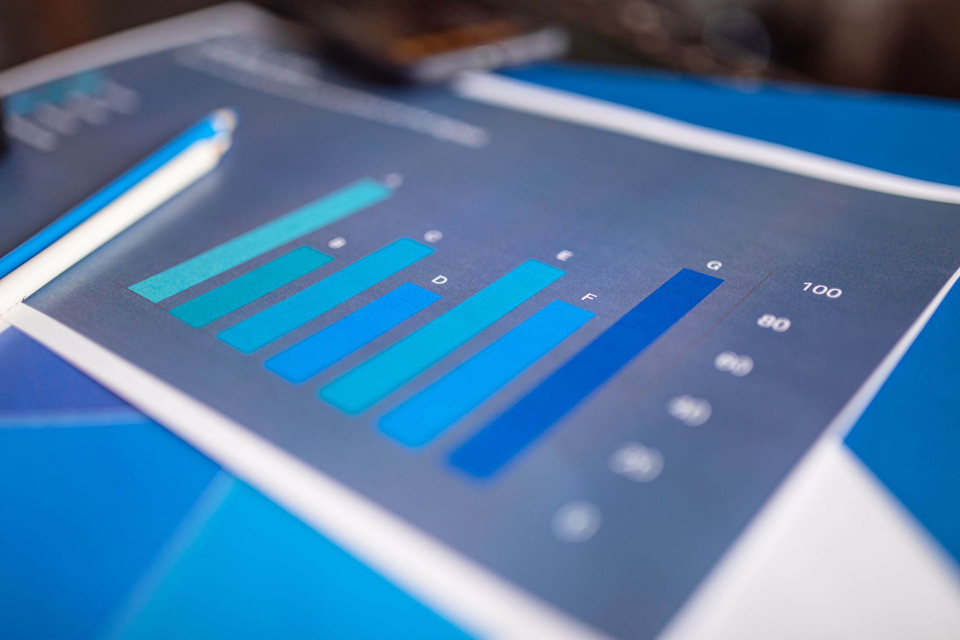 Ilustrasi: Detailed close-up of a blue bar graph showing data analysis on printed paper.
