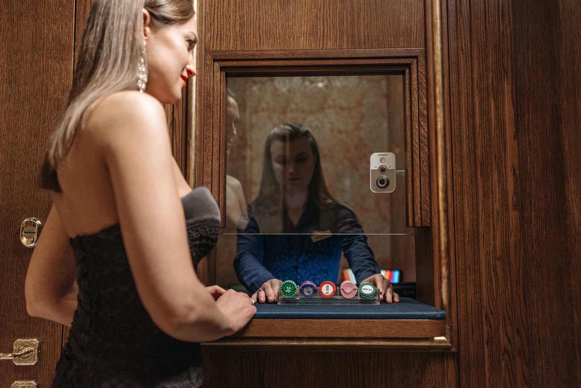 Ilustrasi: A woman at a casino desk receiving chips from a cashier, highlighting glamour and gambling.