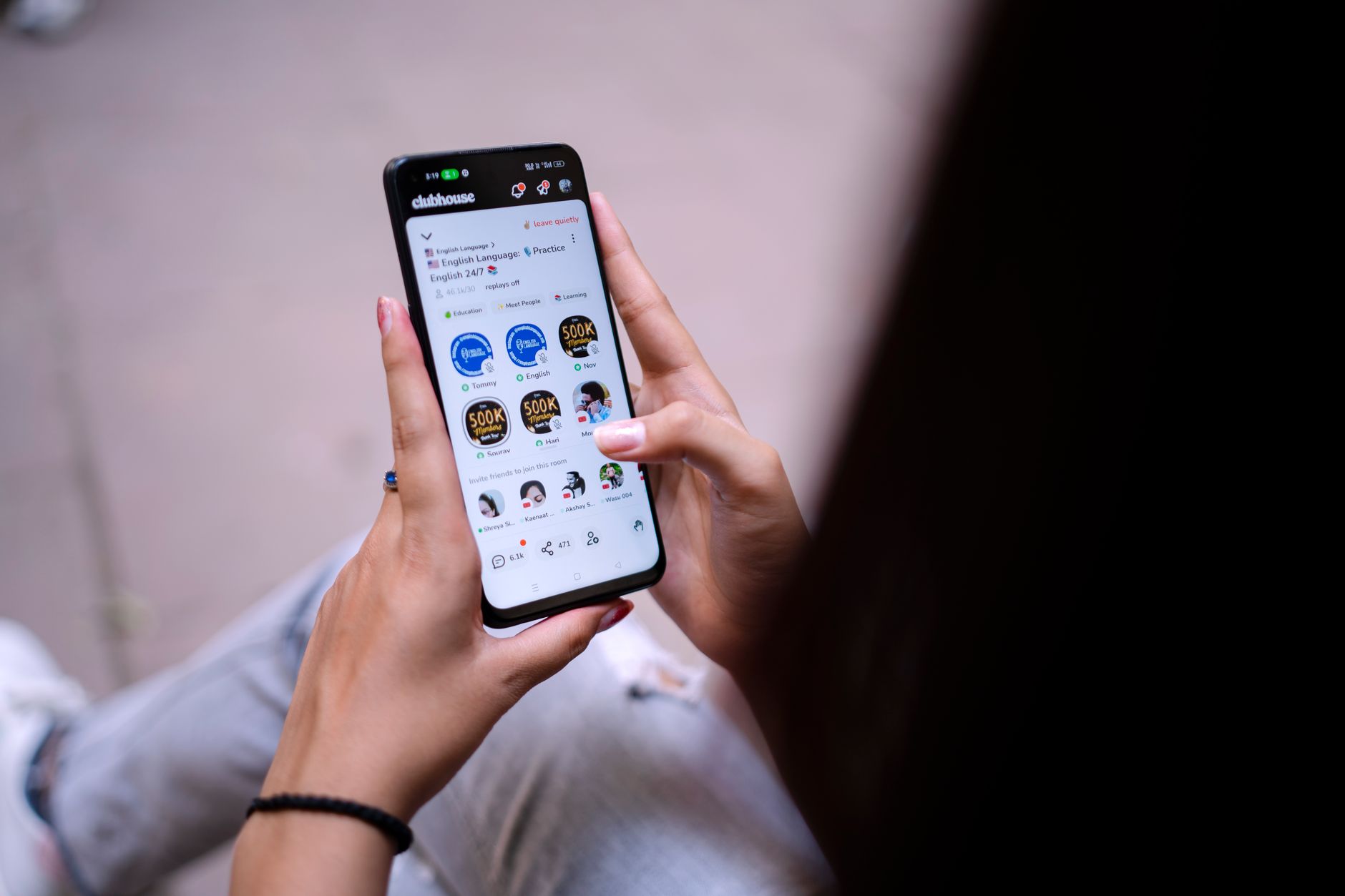 Ilustrasi: Close-up of a woman using a smartphone with social media app open. Hands holding device.