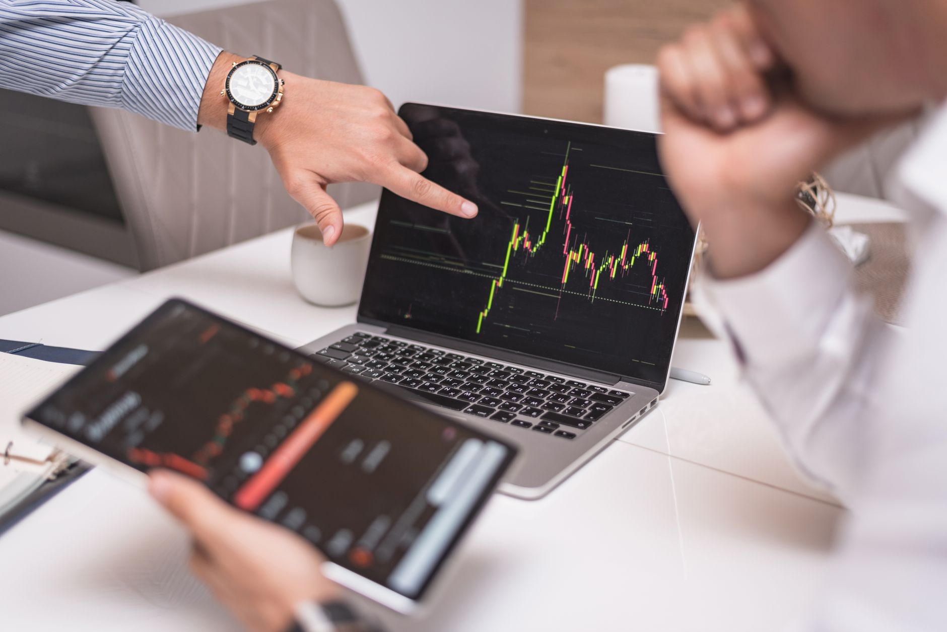 Ilustrasi: Business professionals analyzing cryptocurrency market trends on laptop and tablet.