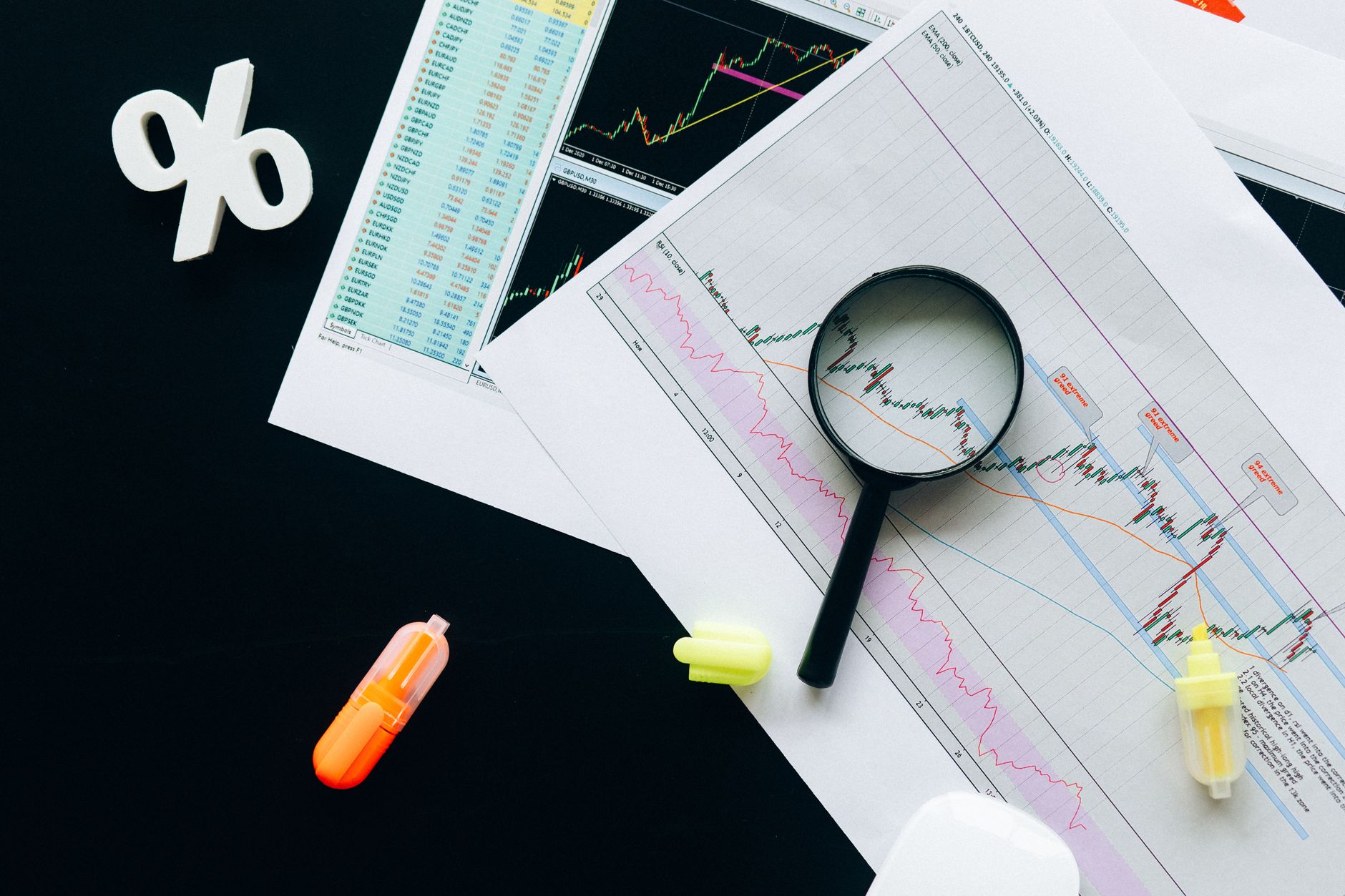 Ilustrasi: High-angle view of financial charts, showcasing stock market analysis with magnifying glass and highlighters.