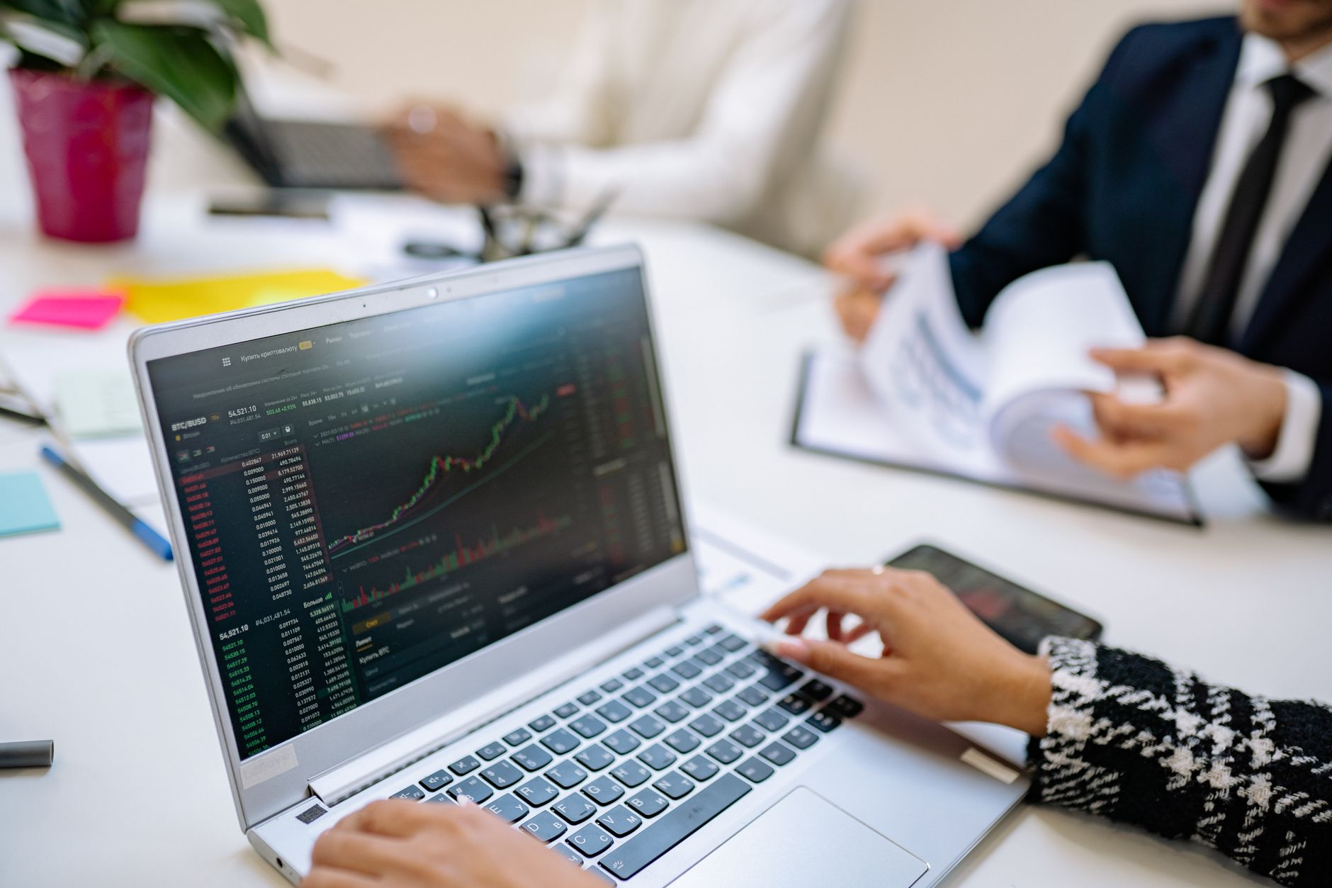 Ilustrasi: Business team analyzes cryptocurrency market trends using a laptop with graphs and data.