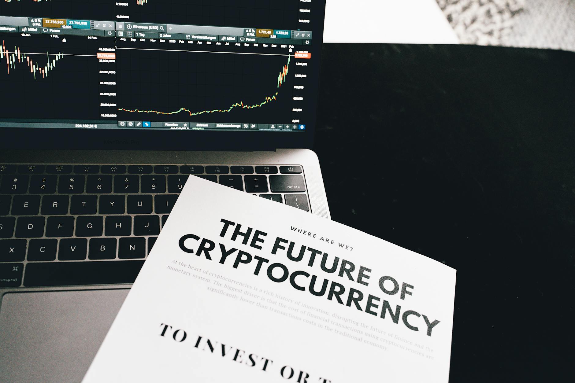 Ilustrasi: A detailed look at cryptocurrency market trends using a laptop and analytical document.