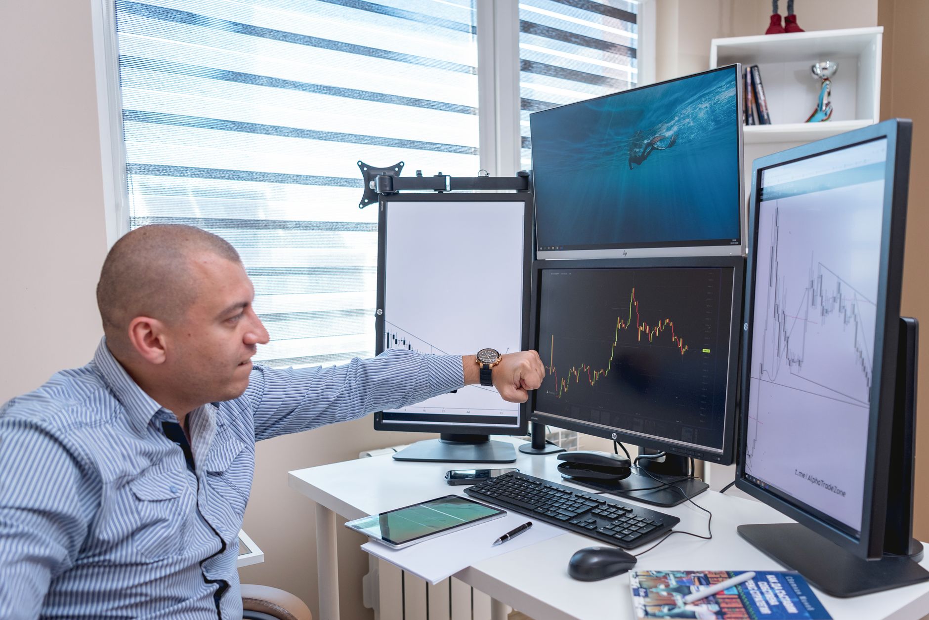 Ilustrasi: A trader analyzing market trends on multiple monitors at an indoor office desk.